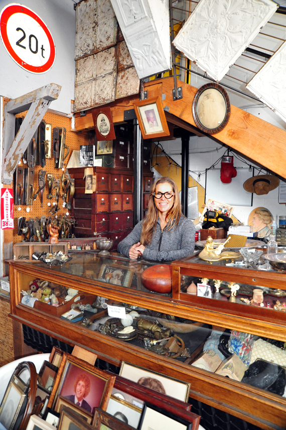 Carrie Clark of Architectural Salvage San Diego climbing a ladder